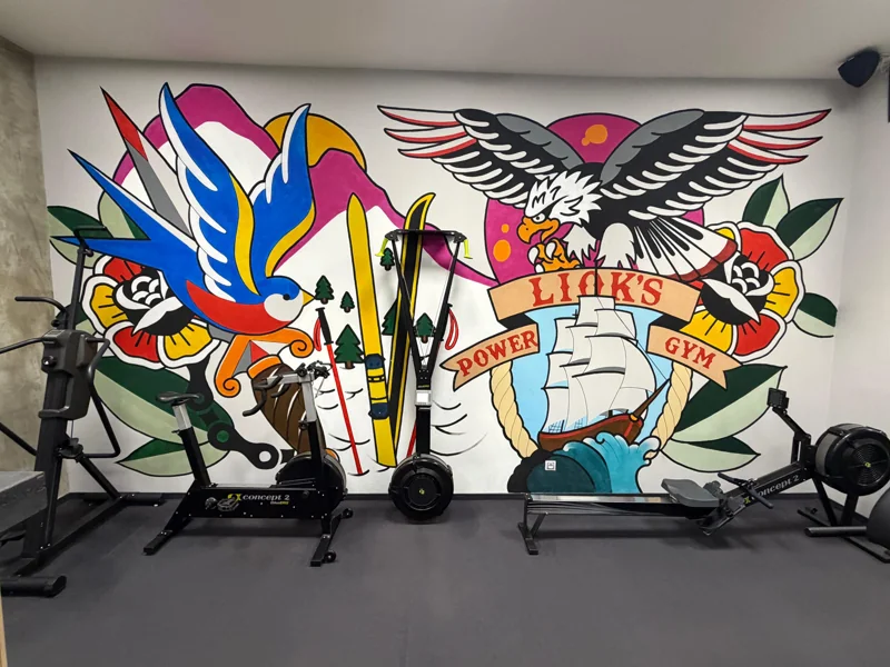 Tetovací malba orla s nápisem Liok’s, v popředí air bike
